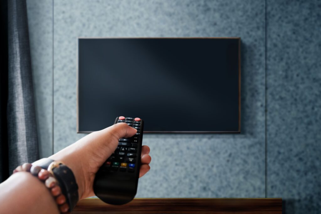 fernsehen konzept beobachten hand die fernsehfernbedienung haelt um kanal zu steuern oder zu aendern 1