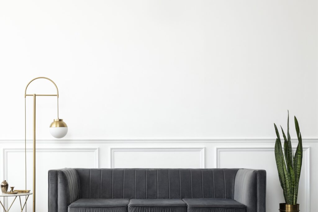 schickes wohnzimmer mit moderner luxusaesthetik aus der mitte des jahrhunderts mit grauer samtcouch und goldener lampe